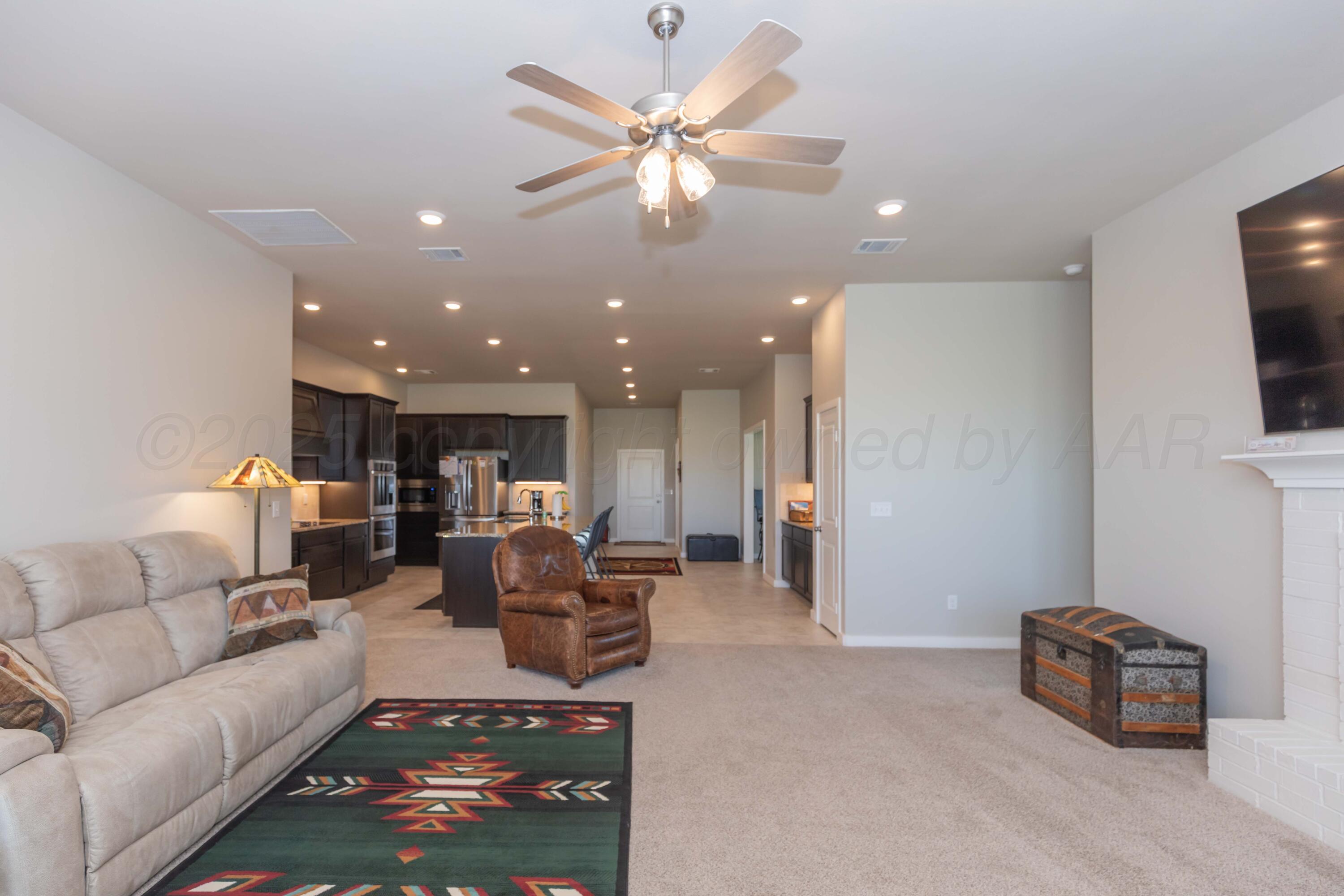 2600 Daybreak Lane Amarillo, TX 79124 - Photo 14 of 52 a living room with furniture a flat screen tv and kitchen view
