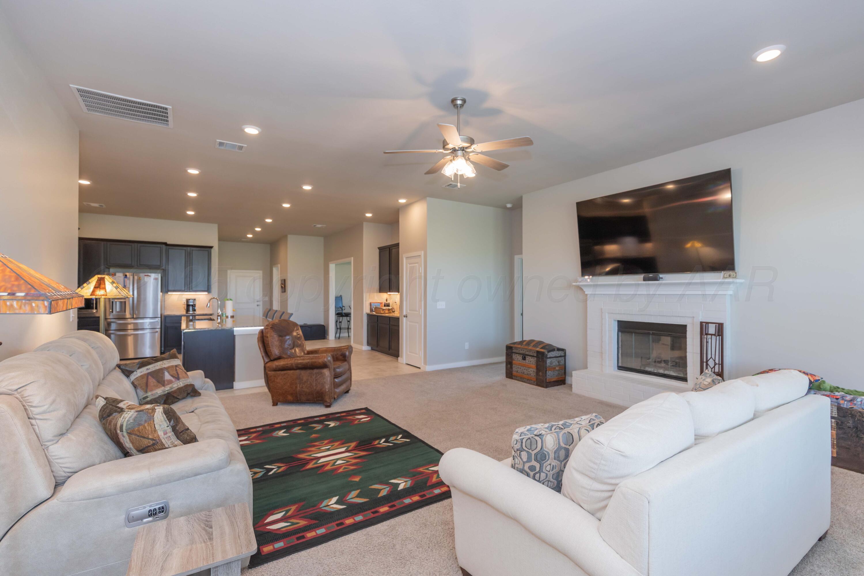 2600 Daybreak Lane Amarillo, TX 79124 - Photo 15 of 52 a living room with furniture a fireplace and a flat screen tv