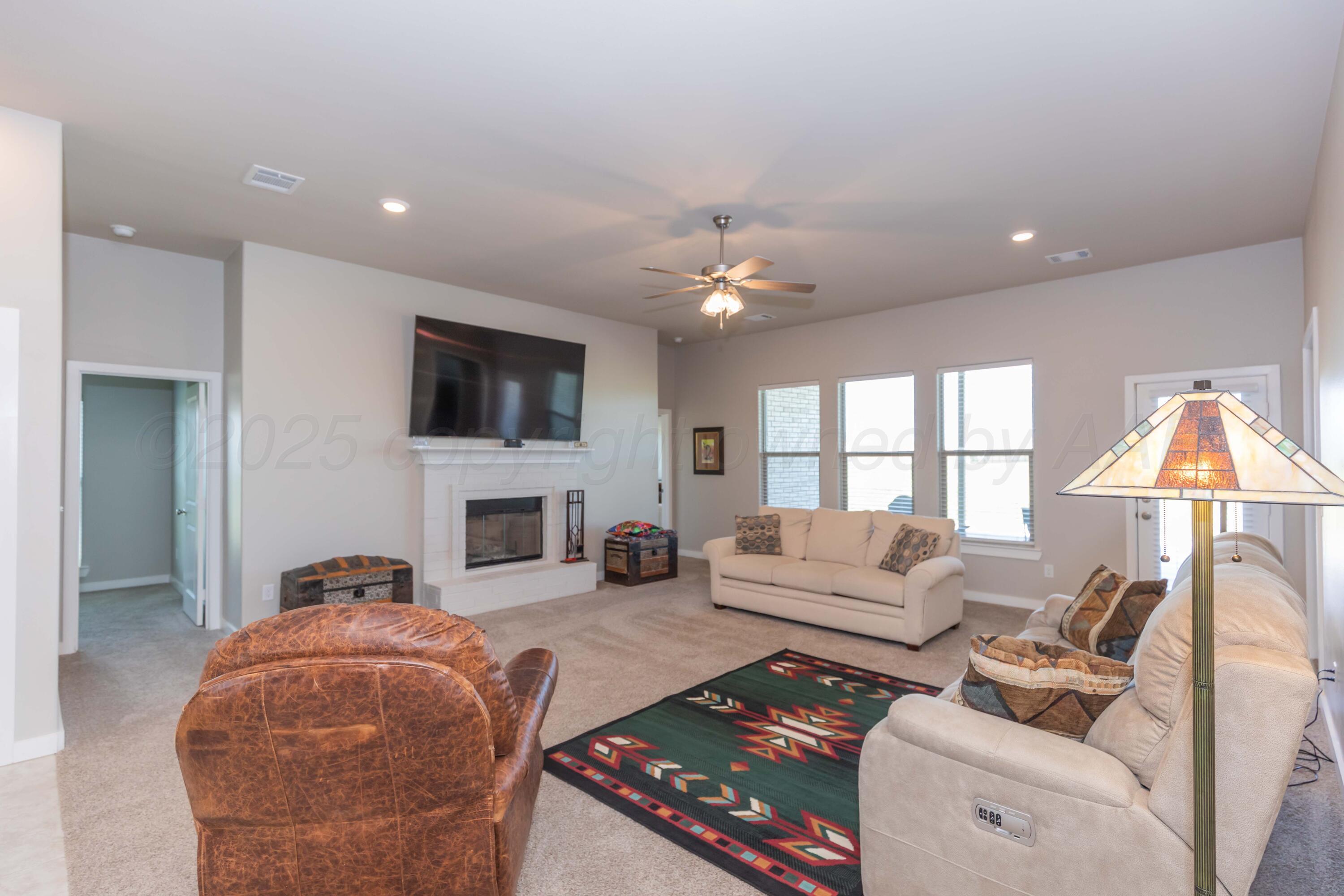 2600 Daybreak Lane Amarillo, TX 79124 - Photo 17 of 52 a living room with furniture a fireplace and a flat screen tv