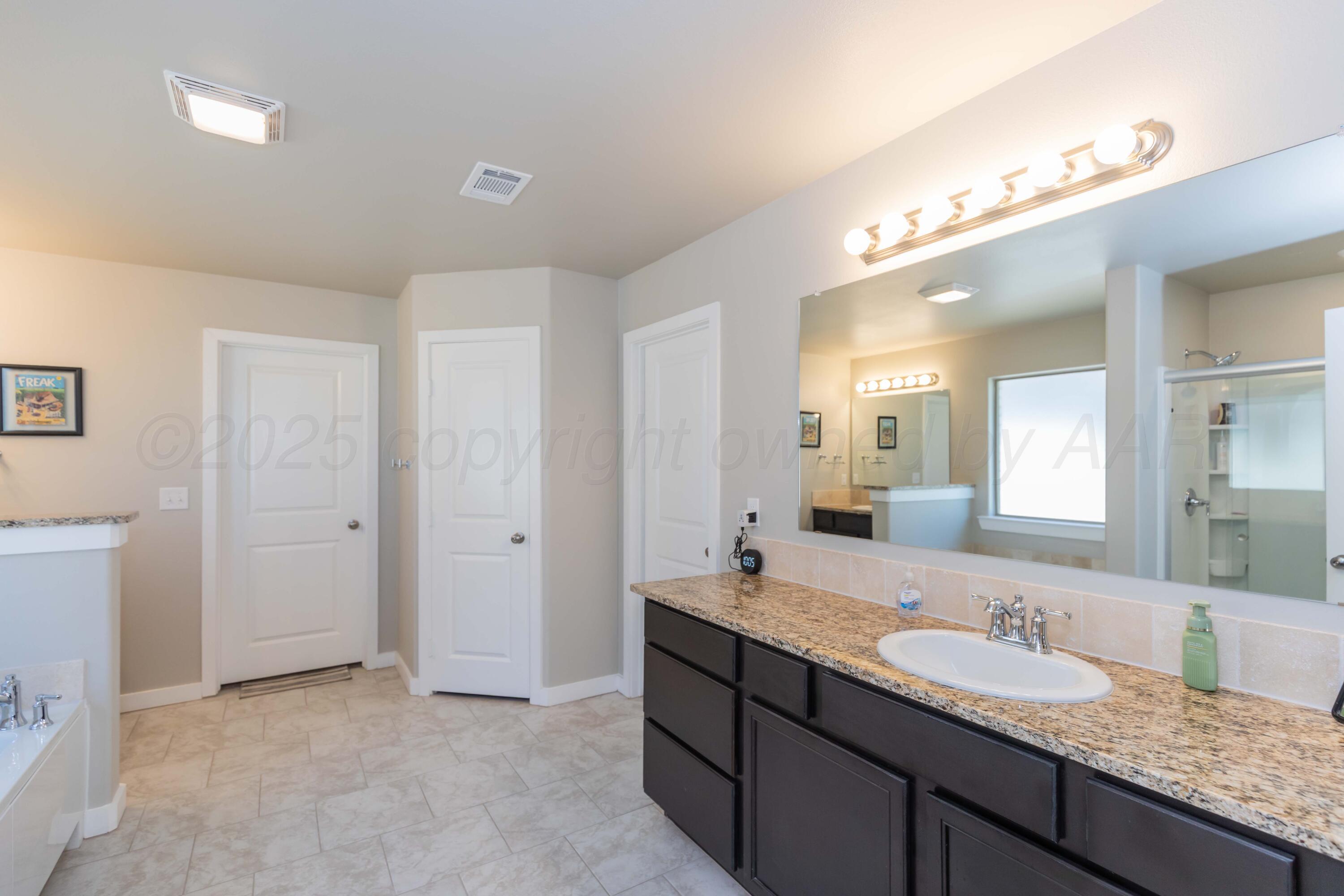 2600 Daybreak Lane Amarillo, TX 79124 - Photo 21 of 52 a bathroom with a granite countertop double vanity sink a mirror and shower