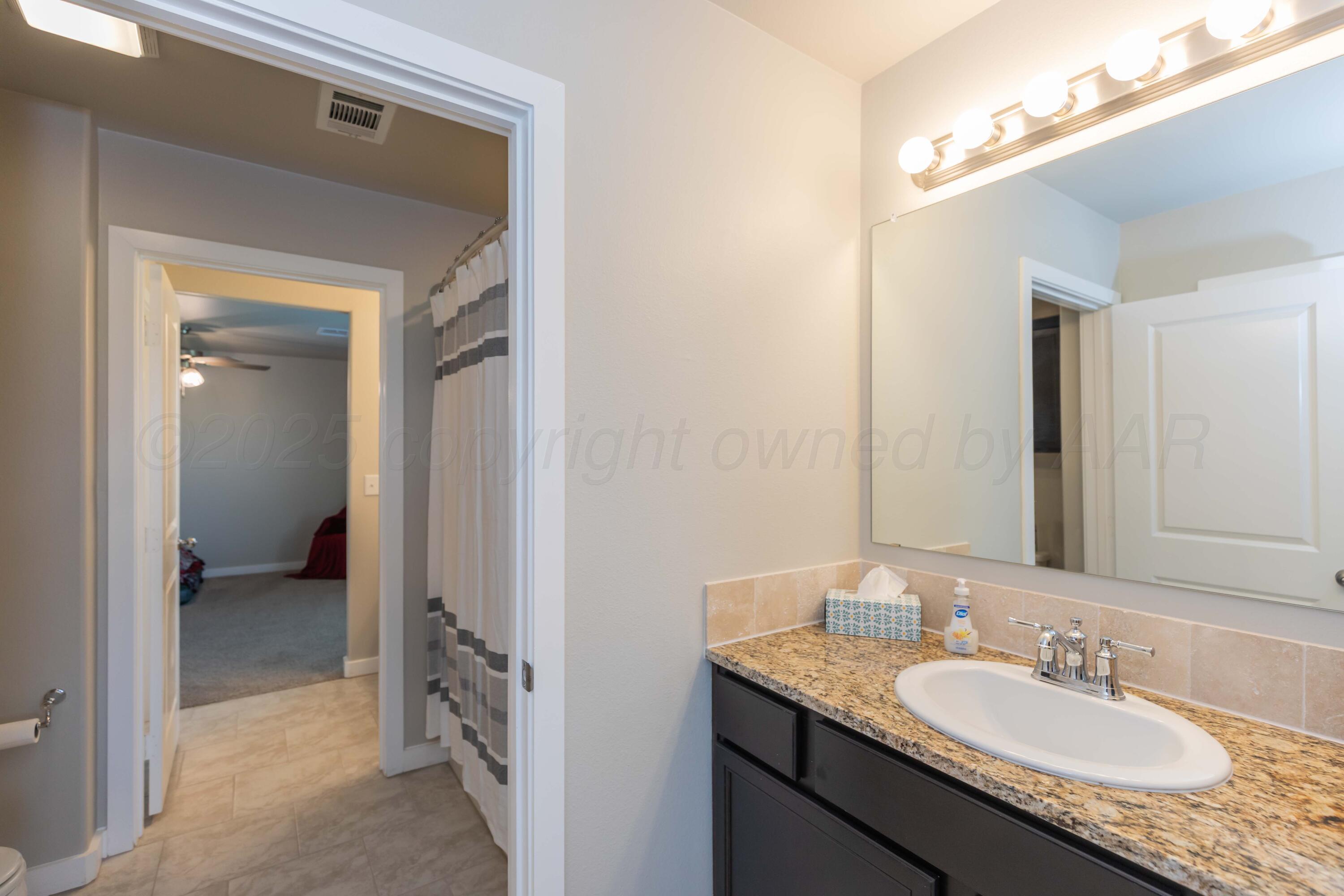 2600 Daybreak Lane Amarillo, TX 79124 - Photo 29 of 52 a en suite bathroom with a granite countertop sink and a mirror
