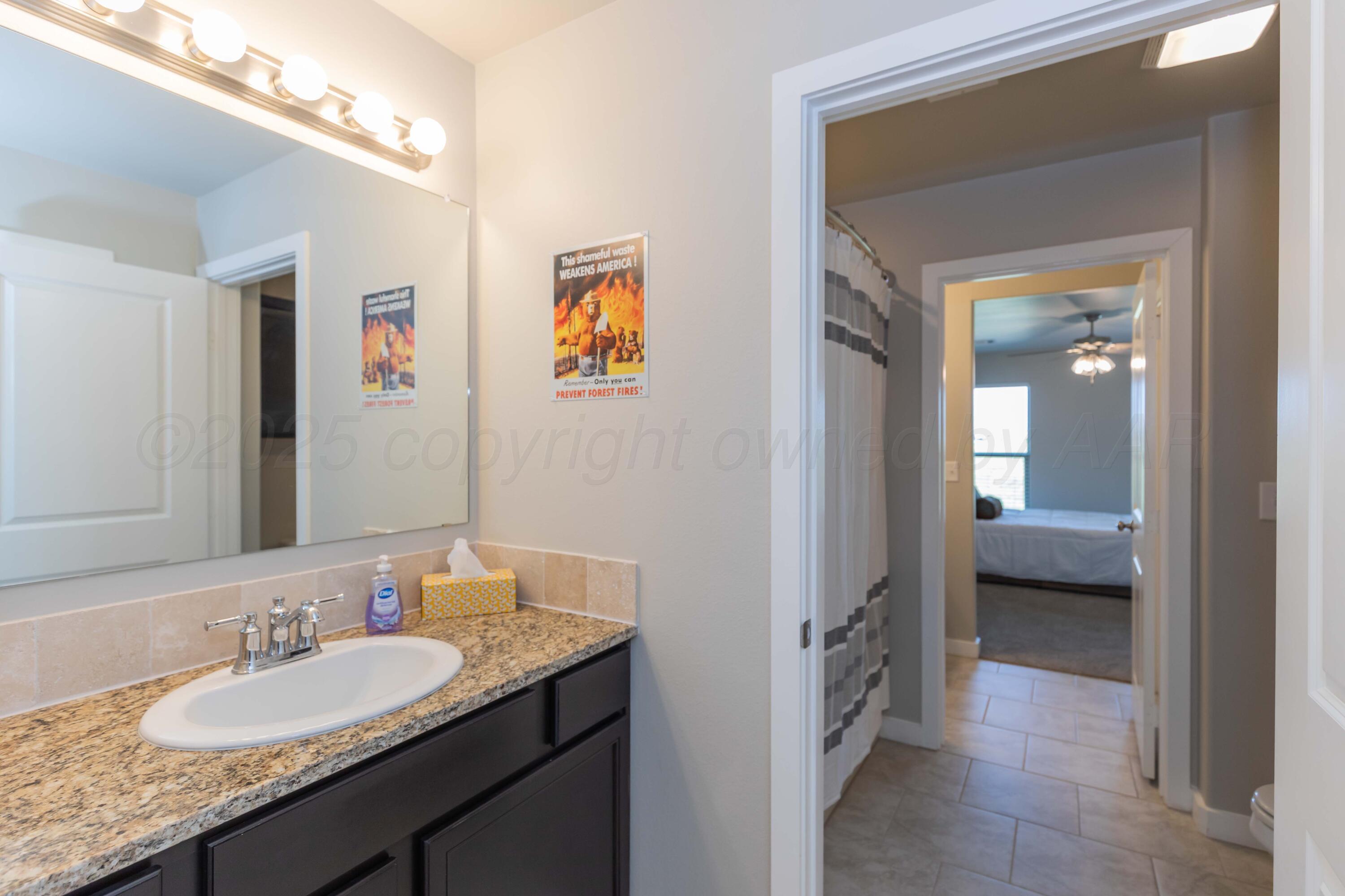 2600 Daybreak Lane Amarillo, TX 79124 - Photo 31 of 52 a en suite bathroom with a granite countertop sink and a mirror
