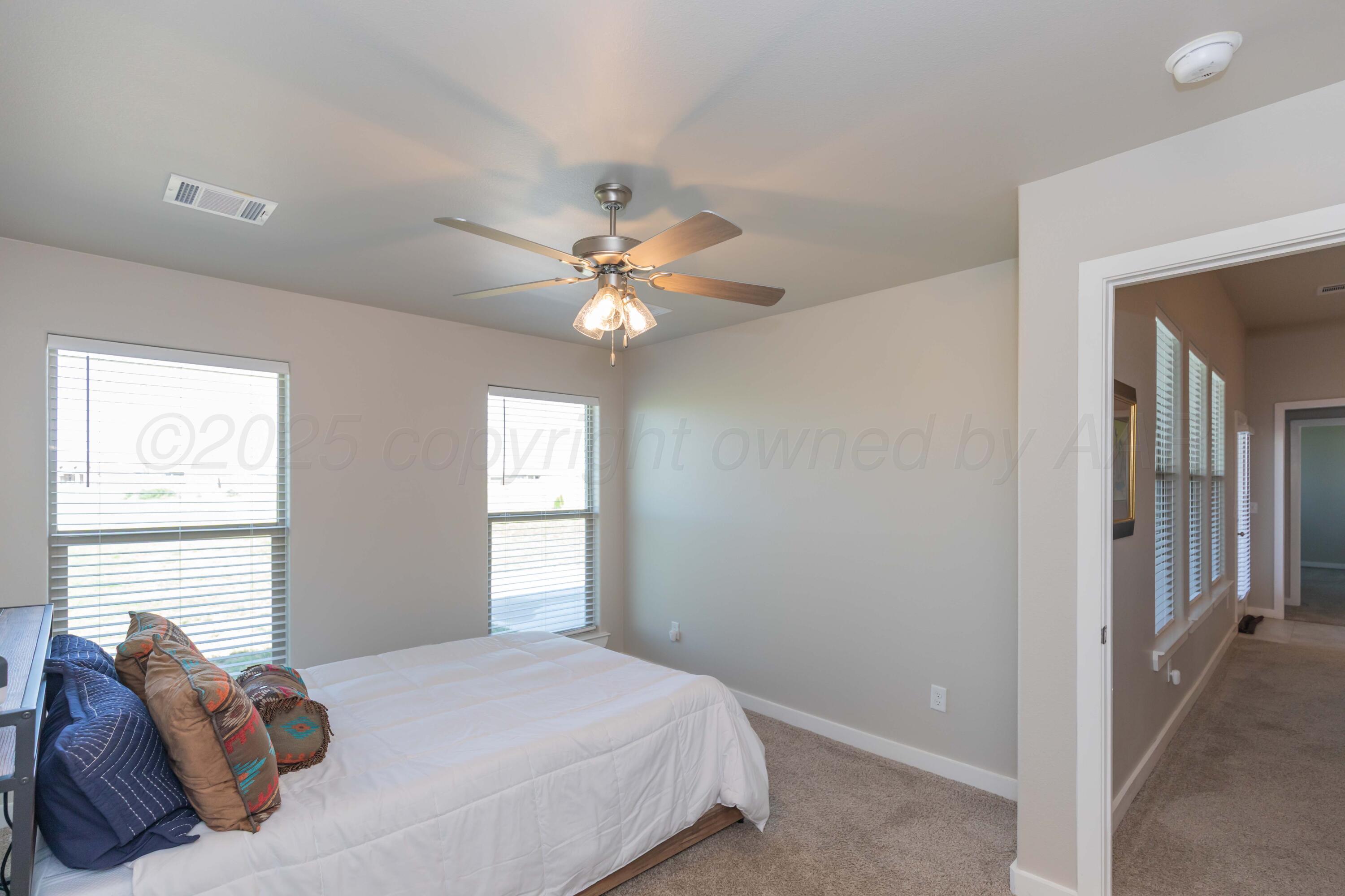 2600 Daybreak Lane Amarillo, TX 79124 - Photo 33 of 52 a bedroom with a large bed and a chandelier