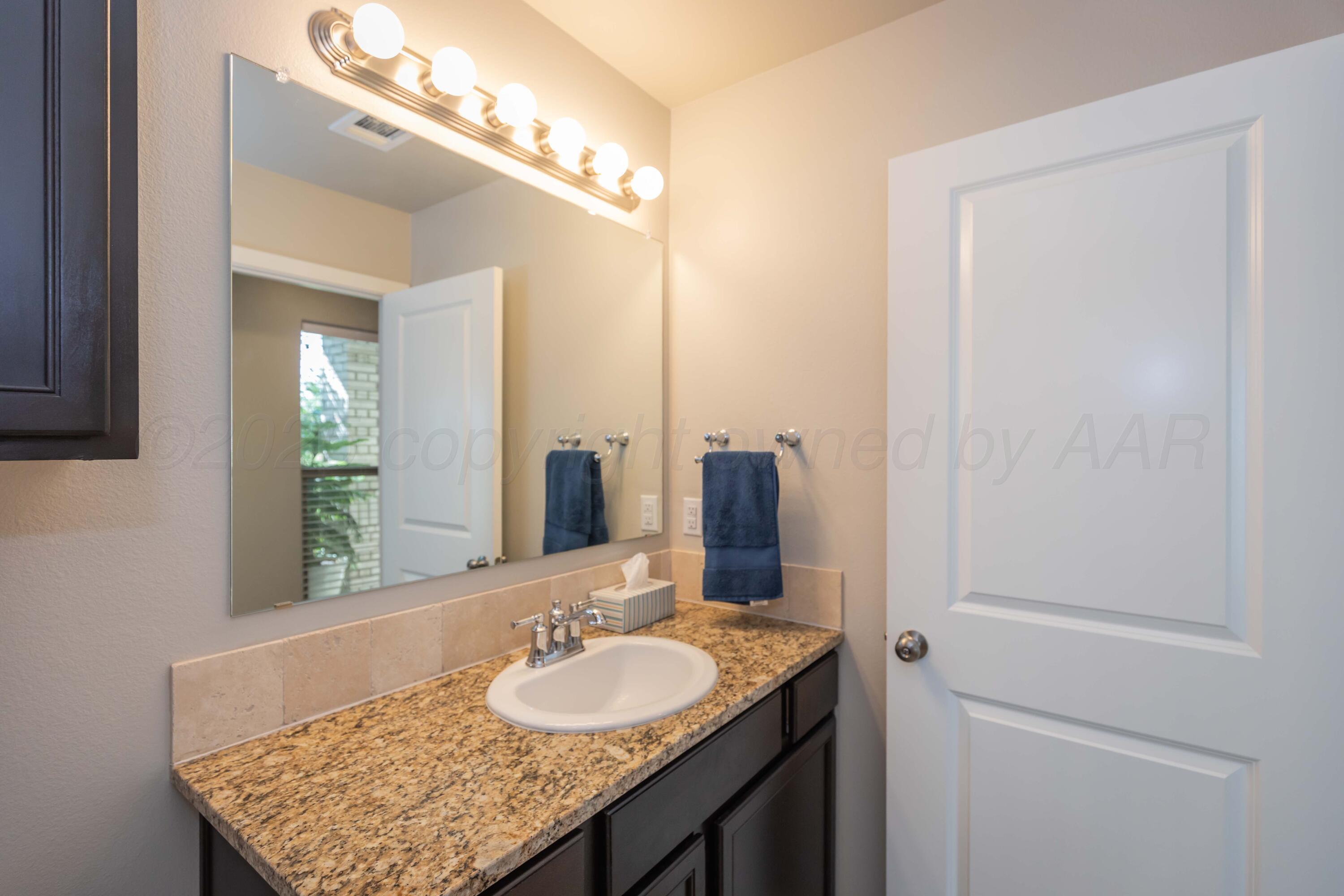 2600 Daybreak Lane Amarillo, TX 79124 - Photo 37 of 52 a bathroom with a granite countertop sink and a mirror