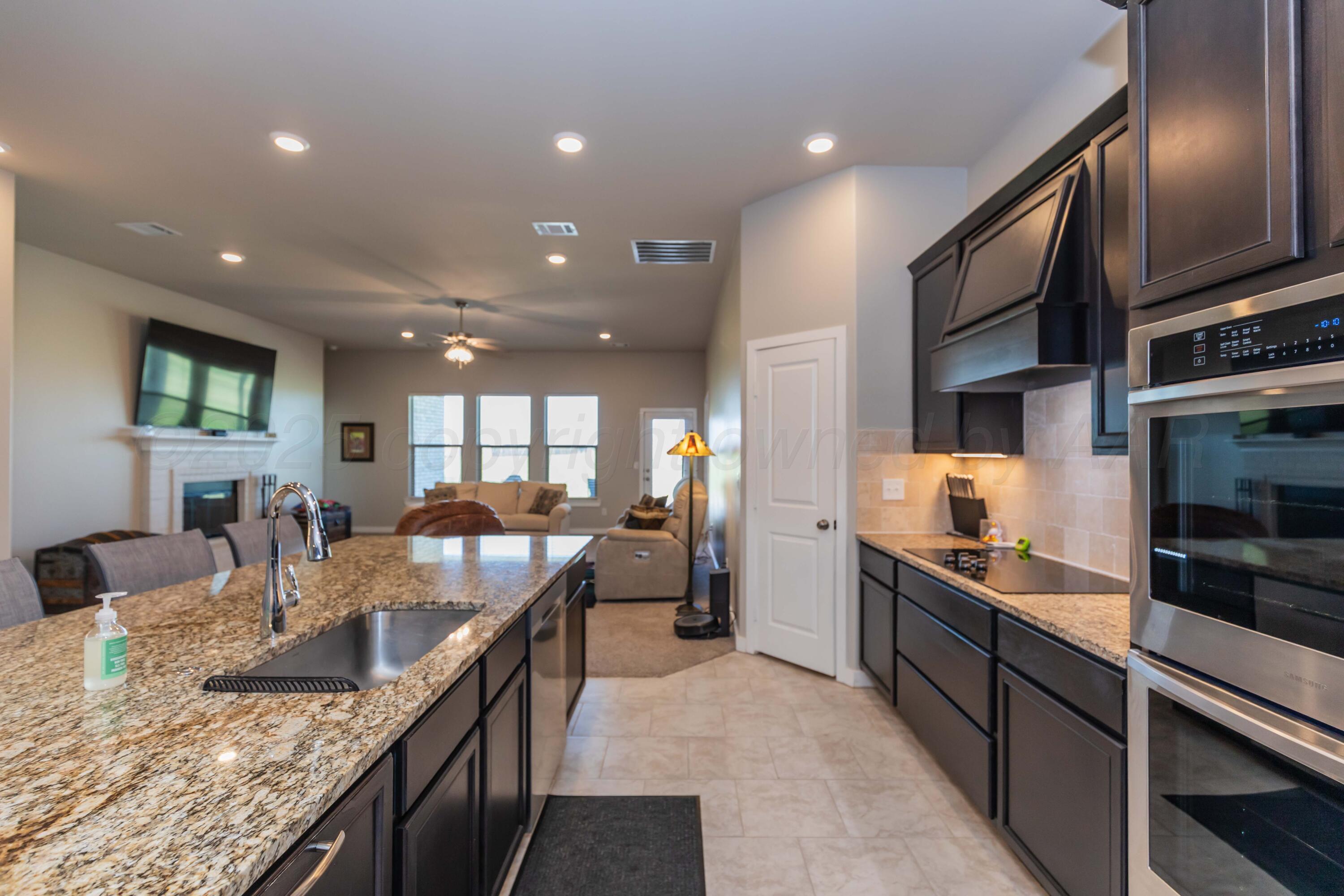 2600 Daybreak Lane Amarillo, TX 79124 - Photo 9 of 52 an open kitchen with granite countertop kitchen island stainless steel appliances a sink a stove and a center island