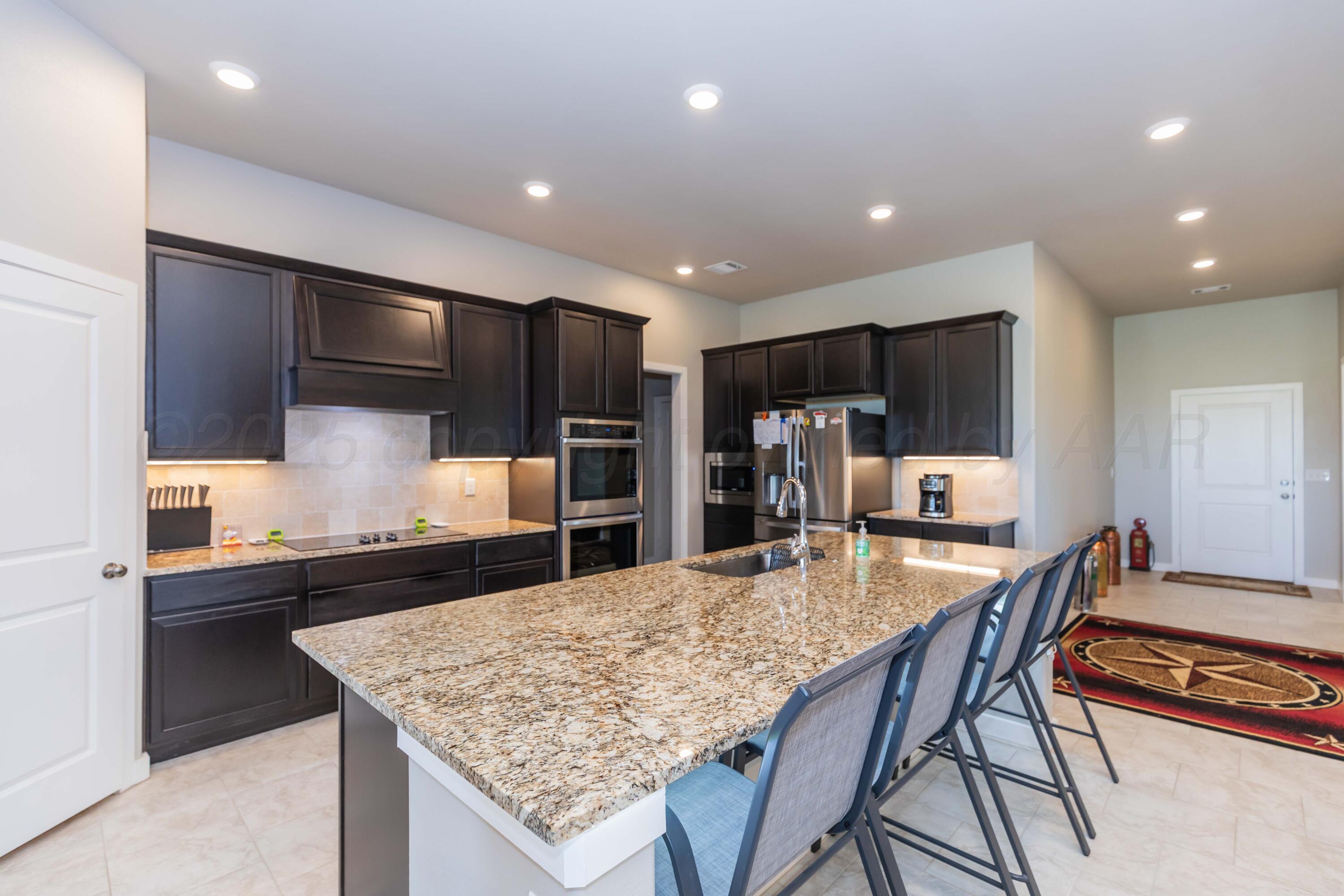 2600 Daybreak Lane Amarillo, TX 79124 - Photo 10 of 52 a kitchen with granite countertop kitchen island stainless steel appliances a sink and counter space