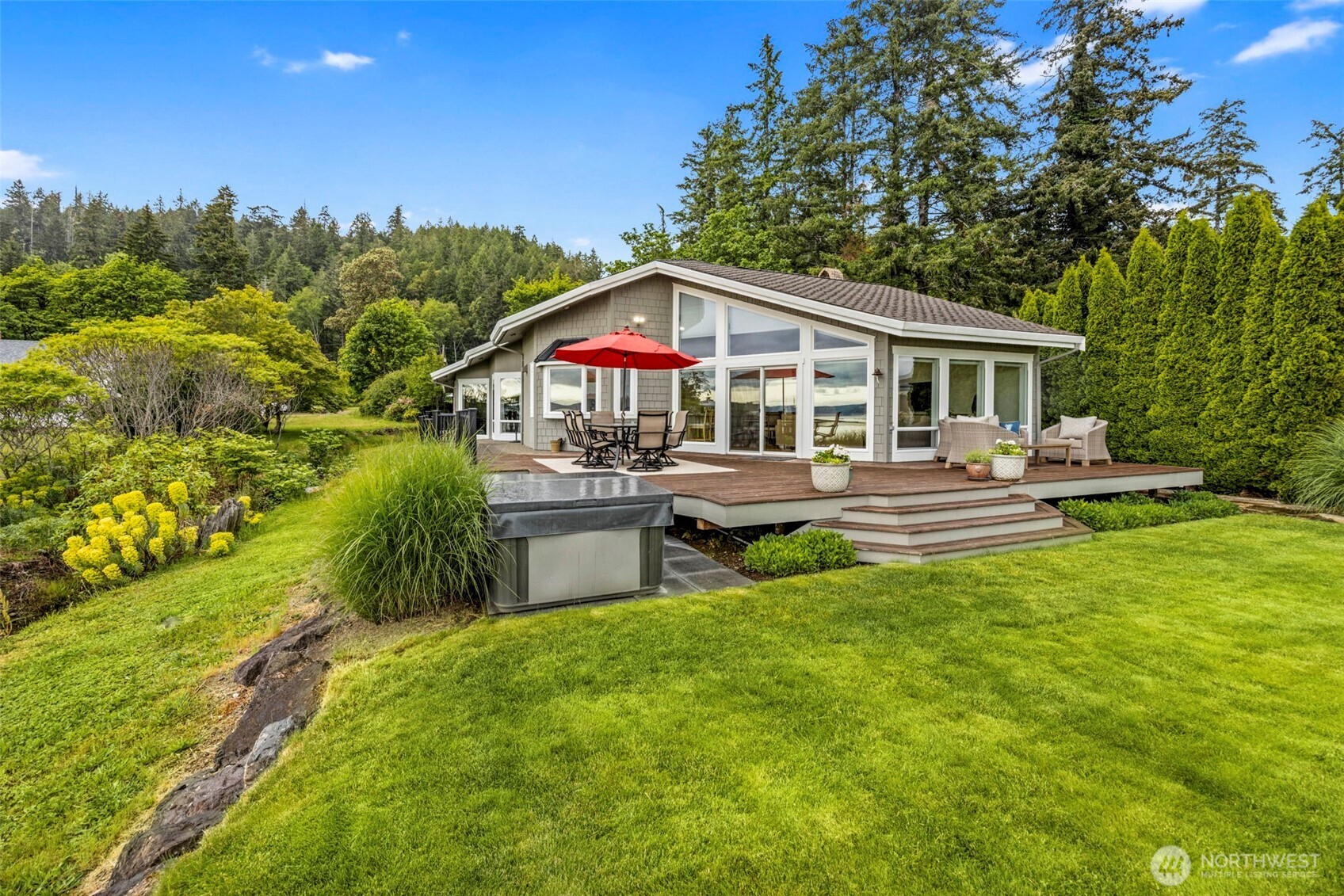 6591 Northeast North Shore Road Belfair, WA 98528 - Photo 2 of 37 a front view of a house with a garden and trees