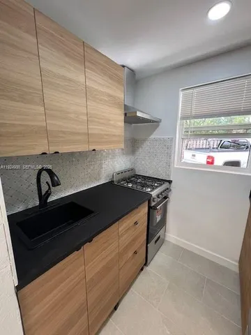 a kitchen with stainless steel appliances granite countertop a refrigerator a sink and a stove