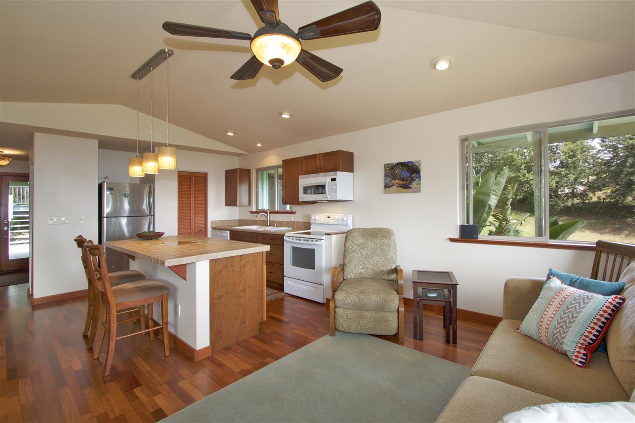 399 Omaopio Road, Unit B Kula, HI 96790 - Photo 5 of 30 a view of a dining room with furniture window and wooden floor