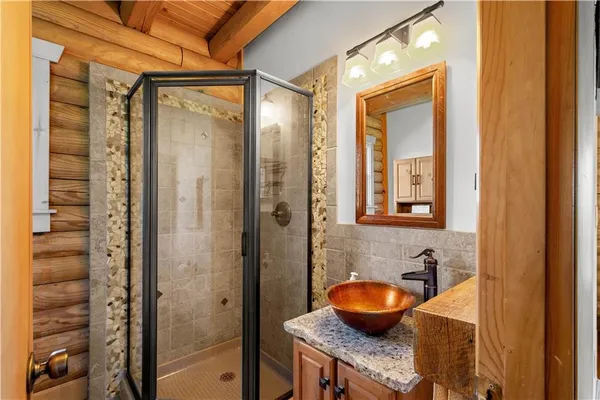 a bathroom with a granite countertop sink and a shower