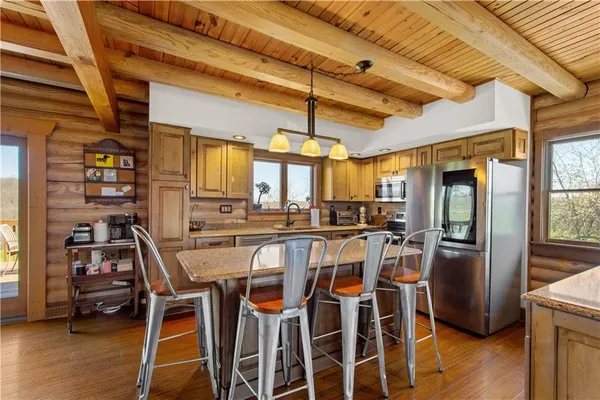 a dining room with stainless steel appliances granite countertop a table chairs and a refrigerator