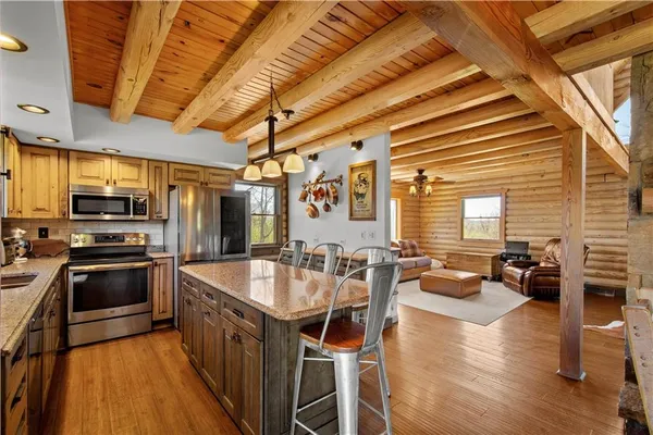 a kitchen with stainless steel appliances granite countertop a sink a stove and a refrigerator