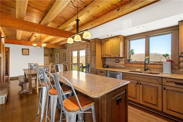 a kitchen with a table chairs sink and wooden floor