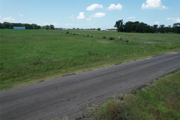 a view of a field with trees in the background