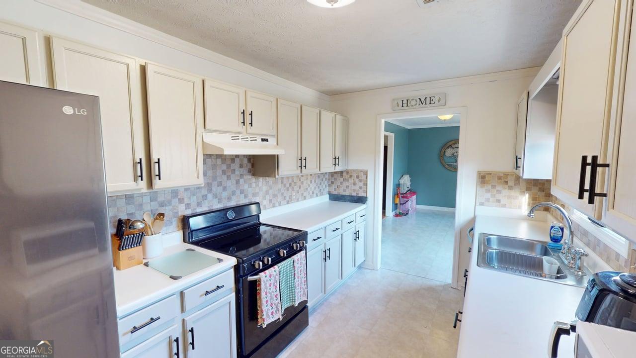 2124 Broad Street Statham, GA 30666 - Photo 15 of 35 a kitchen with stainless steel appliances granite countertop a stove and a sink