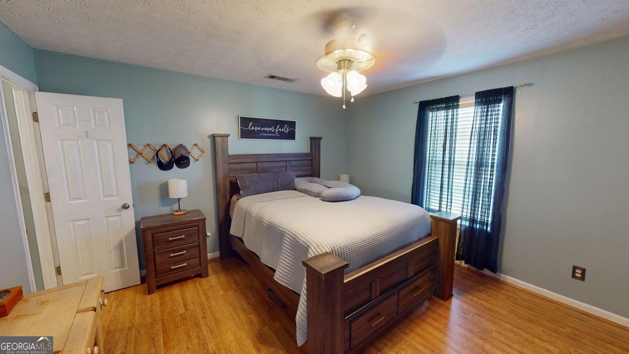 2124 Broad Street Statham, GA 30666 - Photo 18 of 35 a bedroom with a bed and wooden floor