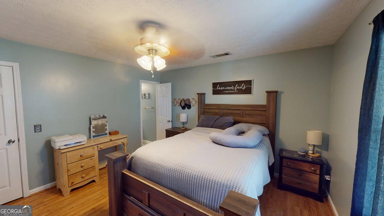 2124 Broad Street Statham, GA 30666 - Photo 20 of 35 a bedroom with a bed and wooden floor