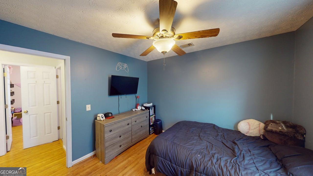 2124 Broad Street Statham, GA 30666 - Photo 25 of 35 a bedroom with a bed and ceiling fan