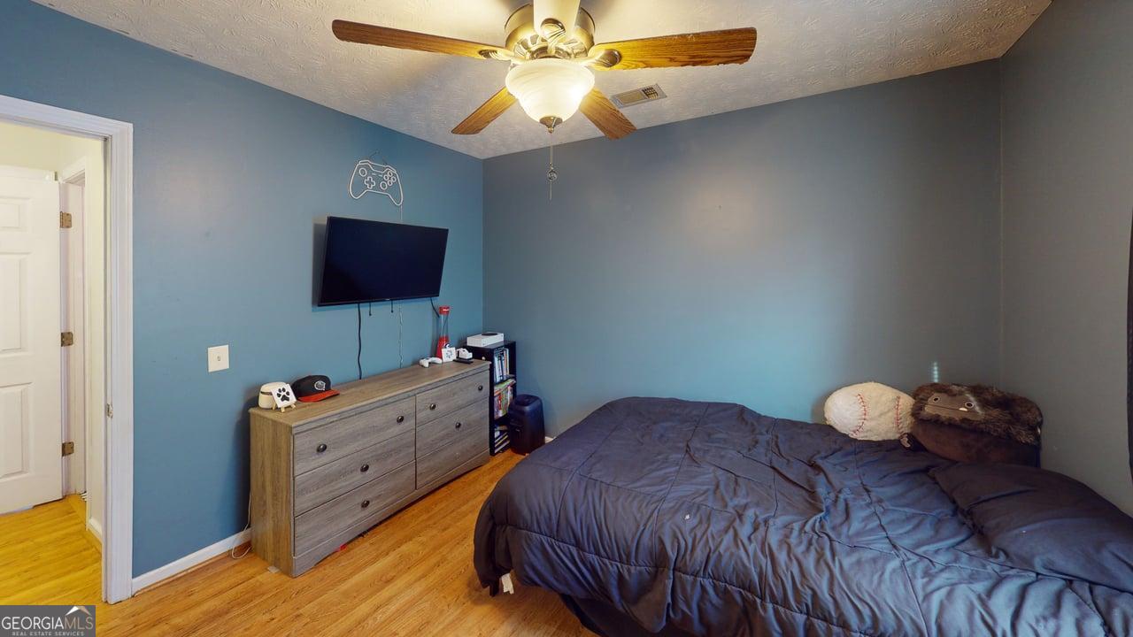 2124 Broad Street Statham, GA 30666 - Photo 27 of 35 a bedroom with a bed and a flat tv screen on dresser