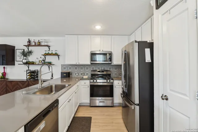 a kitchen with a sink stainless steel appliances and cabinets