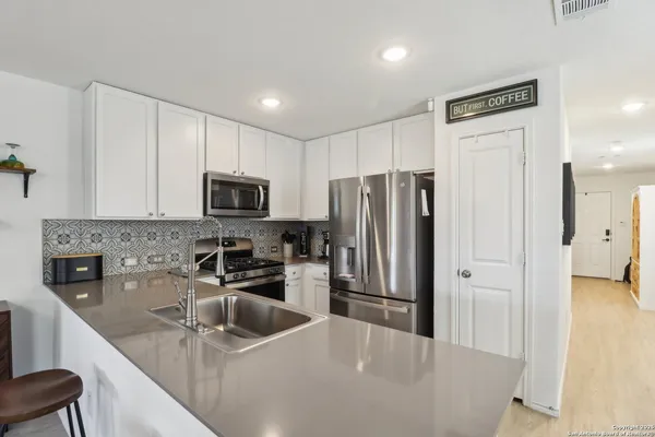 a kitchen with stainless steel appliances granite countertop a refrigerator a stove a sink and a microwave