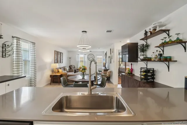 a kitchen with a sink a counter and chairs