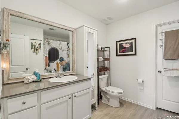 a bathroom with a granite countertop toilet a sink and a mirror