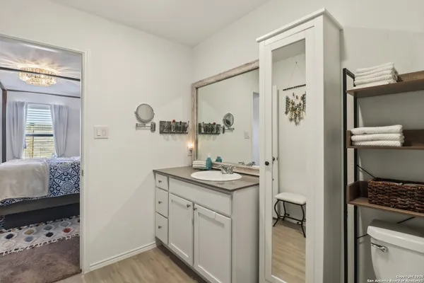 a en suite bathroom with a granite countertop sink and a mirror