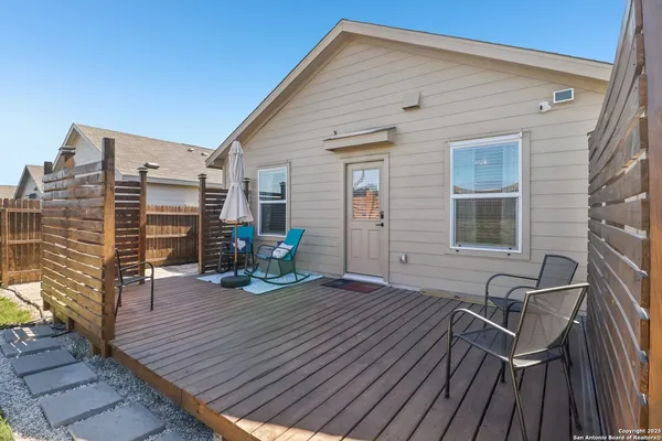 a view of a roof deck with table and chairs with wooden floor and fence