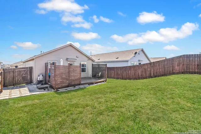 a view of a backyard with plants and large tree