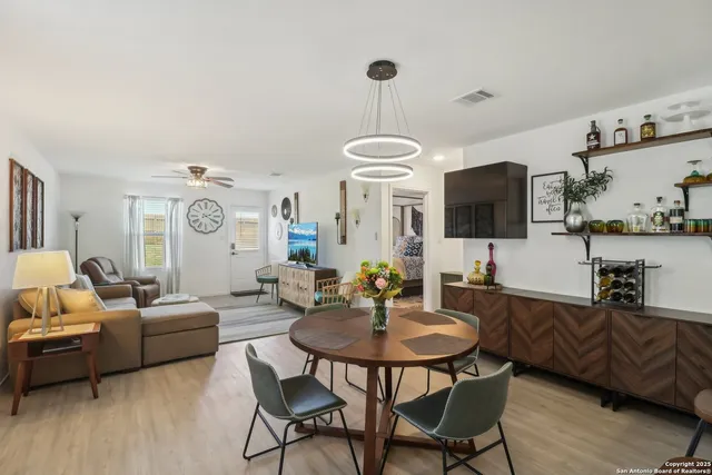a living room with furniture a flat screen tv and kitchen view