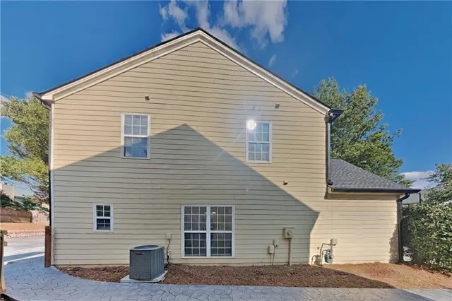 a view of house that has a small yard and large window