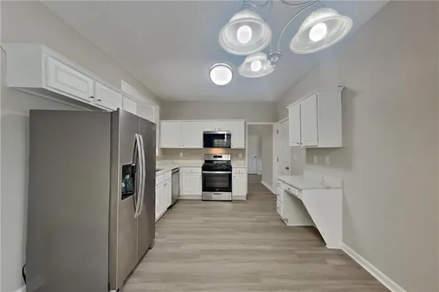 a large kitchen with cabinets and stainless steel appliances