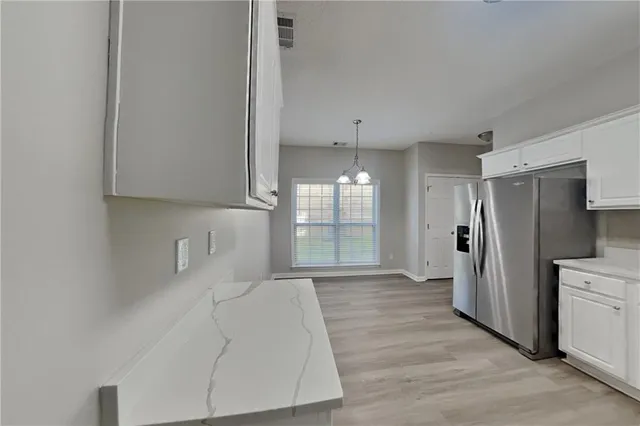a large white kitchen with cabinets and a refrigerator