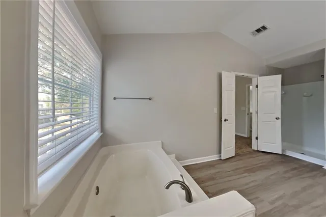 a room with a bed and wooden floor