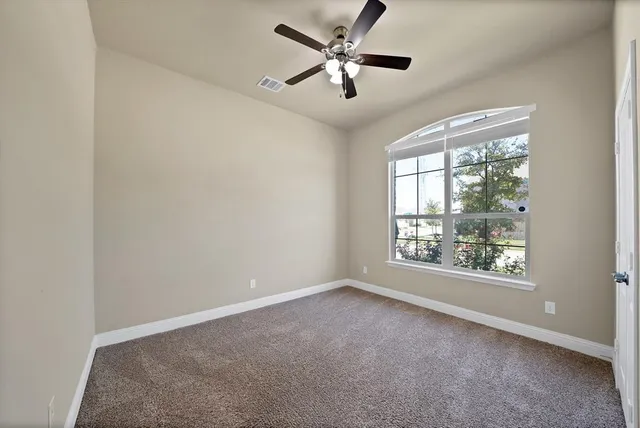 a view of an empty room with a ceiling fan