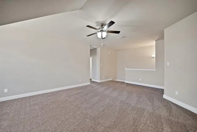 a view of an empty room with a ceiling fan