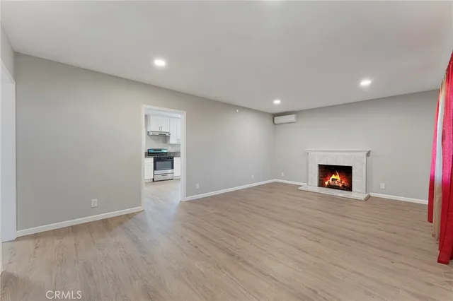 a view of an empty room with a fireplace and a window