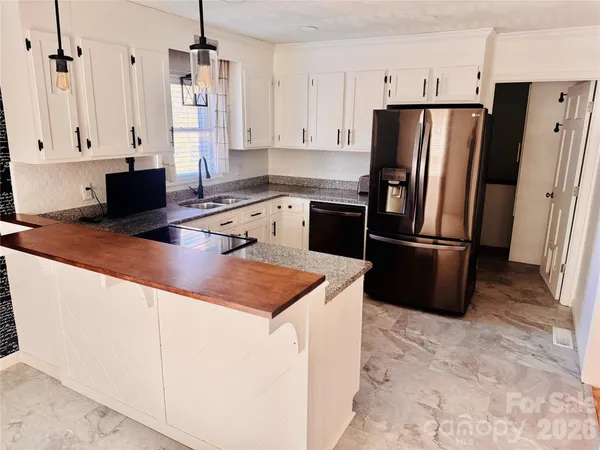 a kitchen with stainless steel appliances granite countertop a refrigerator a stove and a sink