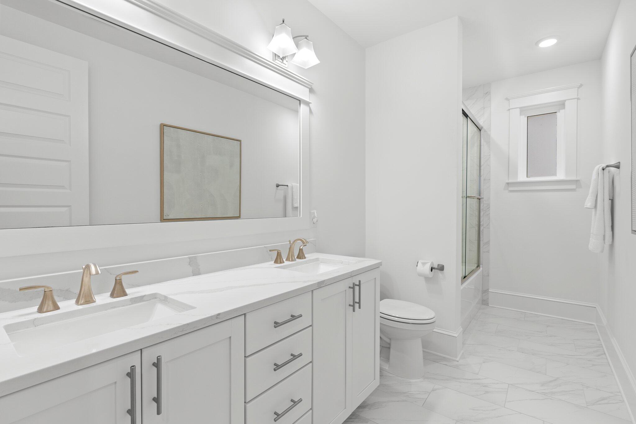 105 Seaboard Lane Santa Rosa Beach, FL 32459 - Photo 24 of 54 a bathroom with a granite countertop sink a toilet and a mirror