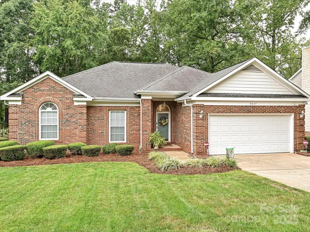 a front view of a house with a yard and potted plants