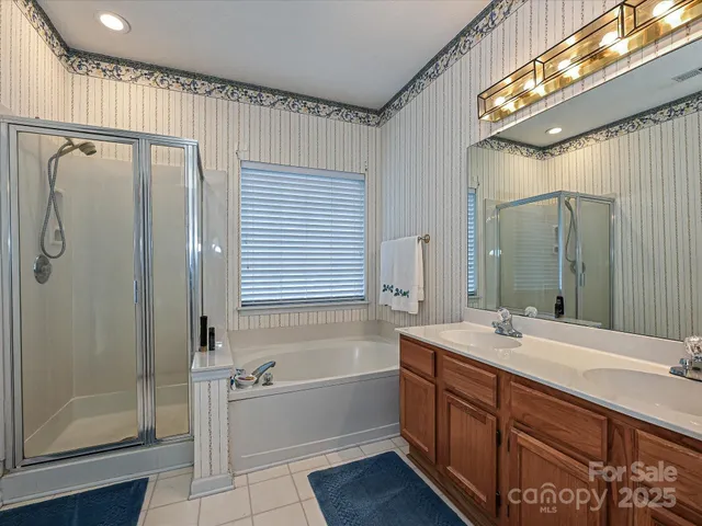 a bathroom with a bathtub shower sink mirror and toilet