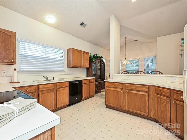 a large kitchen with stainless steel appliances granite countertop a sink dishwasher stove and oven