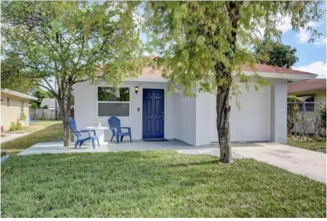 a view of a house with backyard and a tree