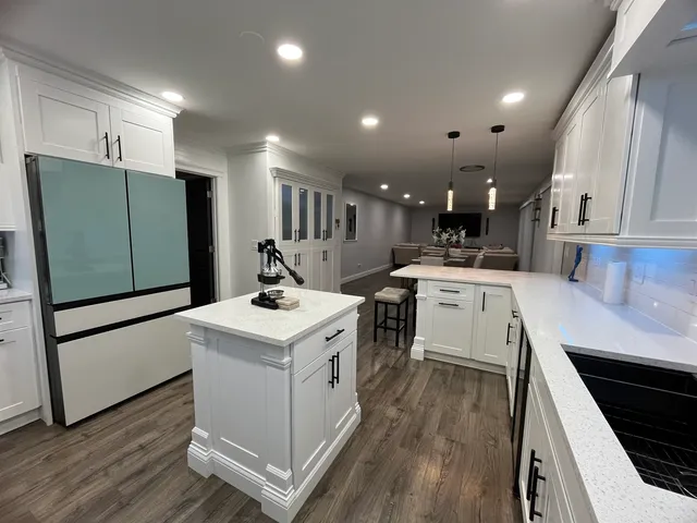 a kitchen with a sink stainless steel appliances and white cabinets