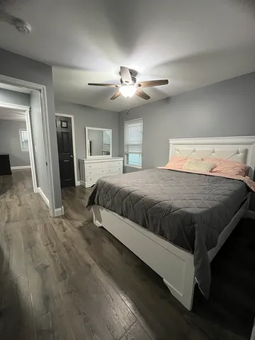 a spacious bedroom with a large bed and a chandelier