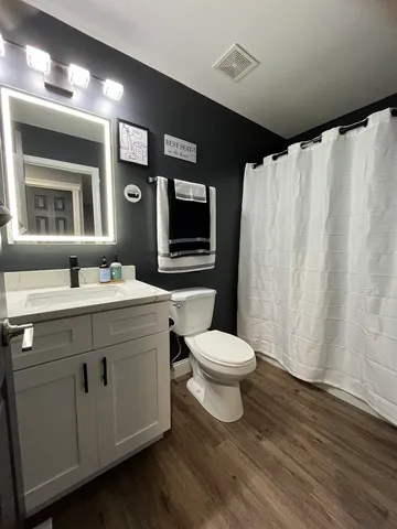 a bathroom with a toilet sink and mirror