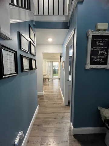 a view of a hallway with wooden floor and staircase