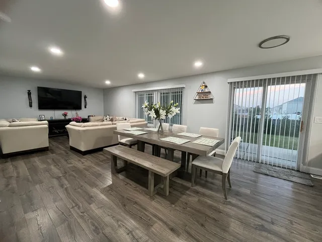 a living room with furniture a flat screen tv and a large window