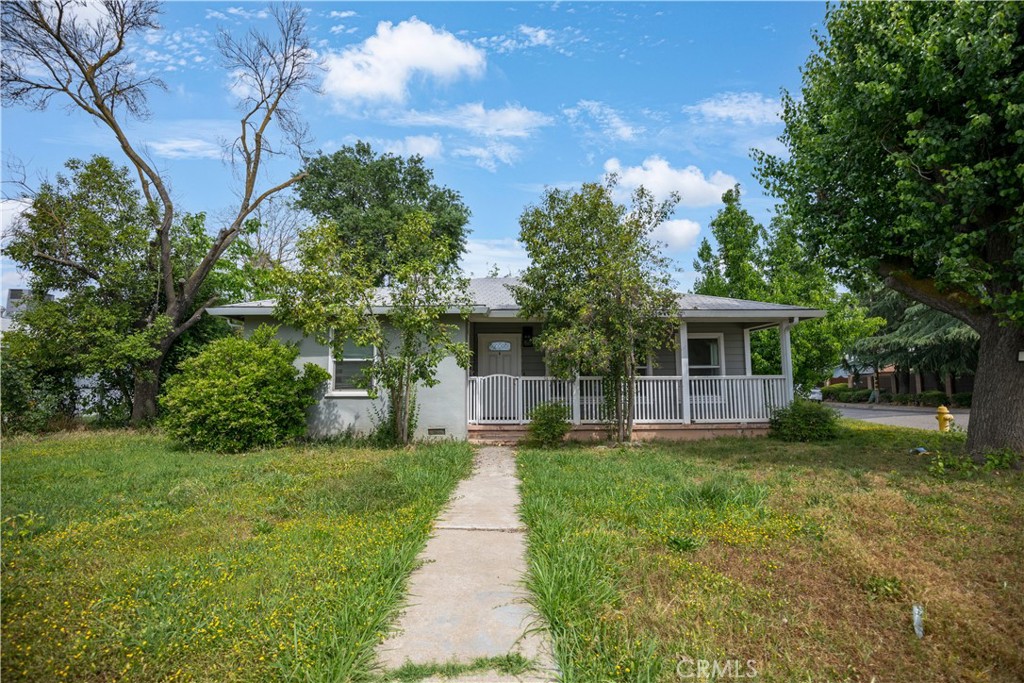 a front view of a house with a yard and trees